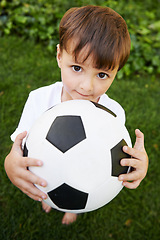 Image showing Portrait, kid and play with football in garden for fun, healthy and childhood development in Brazil. Closeup, sweet and young boy with soccer ball for afternoon game or exercise in backyard or park