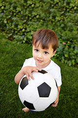 Image showing Portrait, boy or play with soccer ball in park for fun, healthy or childhood development in Morocco. Happy, young and male child with football for afternoon game or exercise in backyard or garden
