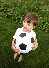 Image showing Soccer, ball and excited child in garden for game, playing and fun on grass at home. Smile, happiness and boy with football, growth and development in backyard for sports for healthy children.