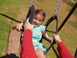 Image showing Portrait, girl and parent on swing in park for summer vacation and fun in a field outside. Little child, family and push while on playground equipment and excited in a garden for bonding on vacation