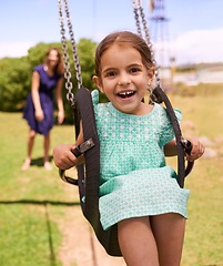 Image showing Portrait, happy little girl ride on swing and in the park watching sunset. Cute toddler, having fun woman swinging her daughter and in kindergarten or leisure activity and weekend summer playground