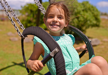 Image showing Cheerful child, swing and playing at a playground with summer hobby for kids or kindergarten leisure activity. Portrait, little girl and outdoor in nature park for fun and happiness with a smile