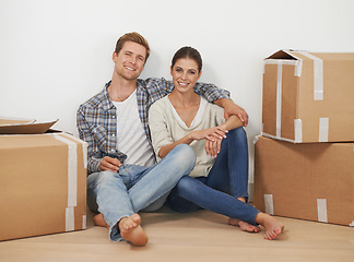 Image showing New home, portrait and happy couple with boxes in living room, moving and relax for investment in real estate. Man, woman and proud homeowners with package in property and mortgage loan for apartment