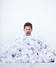 Image showing Man, desk and frustrated with pile of paperwork, crisis and tired with burnout, stress and administration. Debt, bills and person lost in documents, overworked and overwhelmed with pressure in office