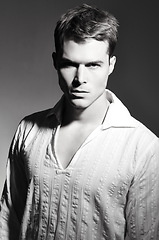 Image showing Fashion, serious and portrait of man in studio with casual, trendy and stylish outfit. Confidence, monochrome and face of handsome young male model with cool style isolated by black background.