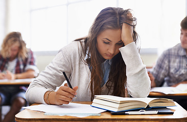 Image showing University, classroom and woman with stress for exam, education and opportunity. College, learning and tired student with book, fatigue and anxiety for test, assessment or studying report with notes.