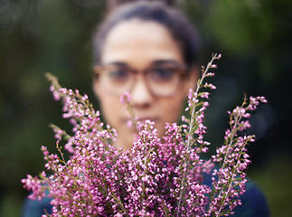Image showing Woman, face and flowers as gift outdoor in nature for gardening in spring and plant for harmony. Peace, backyard and home to calm person with present of fresh bouquet in purple to relax and enjoy