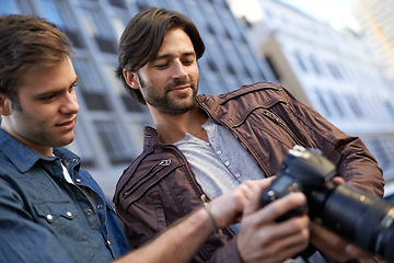 Image showing Men, friends and photographer with camera in outdoor, capture and city for creativity in London. Collaboration, photography and take picture of urban town, events and buildings for portfolio