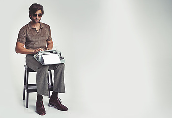Image showing Man, fashion and vintage with typewriter in studio on grey background, confident and typing in chair. Mockup, writer, and manuscript in retro look with smart style in elegance, clothes and glasses
