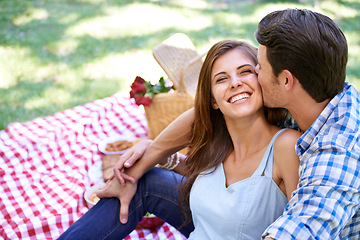 Image showing Love, picnic and happy couple kiss in park for summer holiday and bonding in nature. Getaway, vacation and man and woman with romance and affection with food for garden, relationship and date