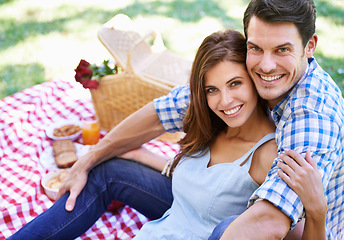 Image showing Portrait, love and happy couple with picnic in the park to celebrate valentines day vacation. Face, smile and man with woman hugging for affection and bonding with food and flowers on nature holiday