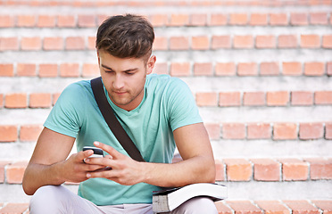 Image showing Phone, university and man on steps with books for learning, studying and knowledge at college. Education, relax and student on cellphone typing for online chat, social media and networking at school