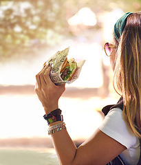 Image showing Hand, fast food and woman eating burger closeup outdoor for hunger, takeaway or craving in summer. Hamburger, lunch or snack with hungry young person holding a fresh beef bun for cuisine or meal