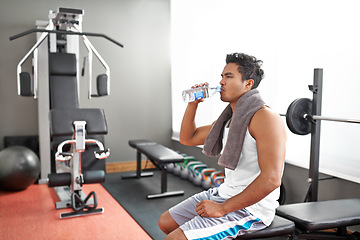 Image showing Fitness, gym and man drinking water for training, wellness or exercise recovery, break or resting. Workout, hydration and thirsty male athlete with sports drink after intense, cardio or bodybuilding