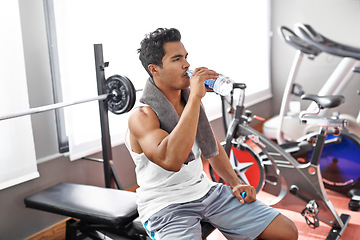 Image showing Gym, fitness and man drinking water for training, wellness or exercise recovery, break or resting. Workout, hydration and thirsty male athlete with sports drink after intense, cardio or bodybuilding