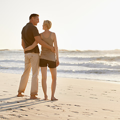 Image showing Love, beach and back of couple at sunset for bonding, relax together and relationship by ocean. Dating, travel and man and woman hug, embrace and smile on holiday, vacation and weekend in nature