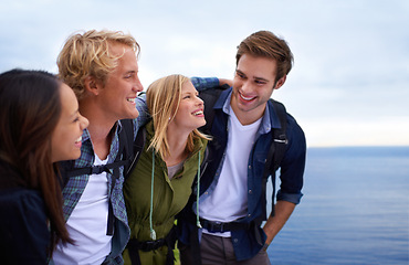 Image showing Friends, group and happy on by ocean for hiking, adventure and talking of eco friendly tourism, travel and sightseeing. Young people with backpack and excited to explore, trekking or outdoor journey