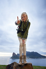 Image showing Woman, hiking and thumbs up on mountain for fitness, outdoor and travel with success, vote and goals in Europe. Portrait of person in backpack and like or yes hand for trekking or adventure by island