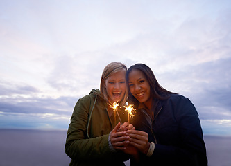 Image showing Women, friends and portrait with sparklers outdoor, celebration and fun with hiking or travel in nature. Friendship, bonding and sparks with horizon, happy for adventure together and evening sky