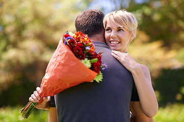 Image showing Hug, happy couple and gift of flowers outdoor in nature, bonding and date on valentines day. Bouquet, man and woman embrace with present for love, care and romantic connection at garden together