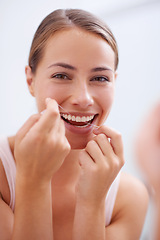 Image showing Portrait, mouth and dental floss for oral hygiene care with woman in bathroom of home for teeth whitening. Face, product and face of young person in apartment to prevent tooth decay or gum disease