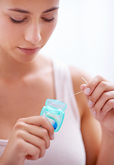 Image showing Dental, health and woman with floss in studio for health, wellness and oral hygiene routine. Treatment, mouth and young female person with product for cleaning teeth isolated by white background.