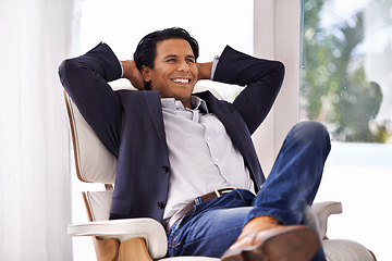 Image showing Relax, stretching and businessman on a chair with relieved, smile or excited about work success in his home. Happy, chilling and male entrepreneur in a living room with chill, moment or stress relief