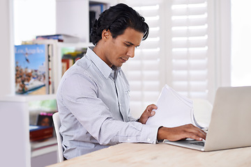 Image showing Businessman, laptop and paperwork at desk in home for remote work, research or online planning in workspace. Financial analyst, person or technology with sales project, stock performance or documents