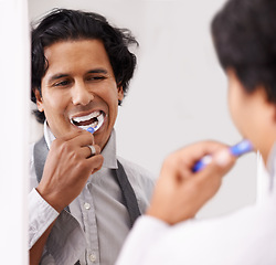 Image showing Dental, mirror and man brushing teeth in a house for hygiene, beauty or morning routine before work. Teeth whitening, mouth and businessman with toothbrush in bathroom for tooth, cleaning or wellness