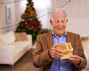 Image showing Christmas, surprise and old man with gift, home and excited with happiness and cheerful in a living room. Pensioner, apartment and elderly guy with present and party with box and retirement with wow