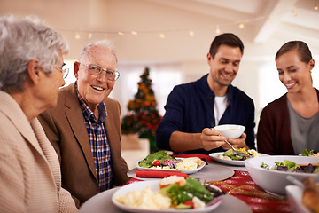Image showing Christmas, happy family and eating lunch in home, smile and bonding together at party. Xmas, food and senior parents at table for festive celebration, relax and people on holiday with salad for meal