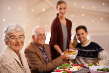 Image showing Grandmother, portrait and family at dinner on Christmas, together with food and celebration in home. Happy, event and people smile with lunch, dish and relax on holiday at table with grandparents