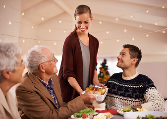 Image showing Family, dinner and smile at table on Christmas, together with food and celebration in home. Senior, mother and father with happiness at lunch with woman hosting holiday and dish of chicken on plate