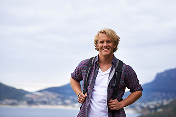 Image showing Man, hiking and portrait on mountains for travel, adventure and wellness by ocean, sea and island in Europe. Face of an excited and young person with backpack for trekking, explore or outdoor journey