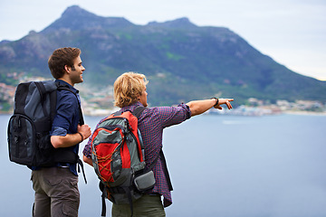 Image showing Friends, hiking and travel on mountains with adventure, explore and view of island, nature and location in Europe. People with backpack and pointing for trekking, journey and destination by the ocean