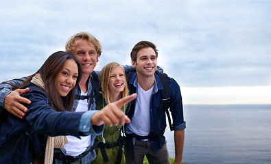 Image showing Friends, group and happy on mountain top for hiking, adventure and pointing to location, travel and sightseeing. Happy young people with backpack and excited to explore, trekking or outdoor journey