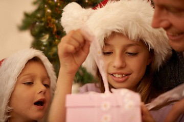 Image showing Christmas, tree and children with gift box, dad for celebration and happy surprise together. Holiday, father and kids smile in living room for present giving, festive xmas and love in family home.