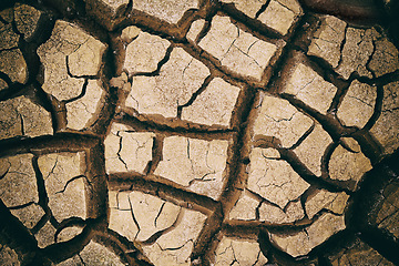 Image showing Earth, dry and ground with cracks, nature and landscape with environment, dust and soil. Empty, barren and drought with extreme weather and climate change with ecology and water shortage with erosion