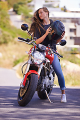 Image showing Woman, motorcycle and relax with helmet on road in city for ride, trip or outdoor sightseeing in nature. Extreme female person, biker or rider sitting on motorbike or vehicle for transport or journey
