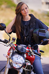 Image showing Happy woman, portrait and biker on motorcycle in city with helmet for road trip, travel or outdoor journey in nature. Female person in confidence for ride, transport or sightseeing in an urban town