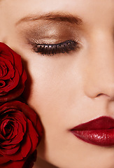 Image showing Closeup of face, makeup and beauty with roses, red lipstick and gold eyeshadow with lashes for cosmetics. Shimmer, shine and bold aesthetic, romantic flowers and cropped with skin and cosmetology