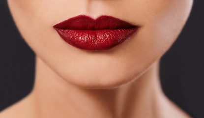 Image showing Closeup, woman and red lipstick for beauty and cosmetics, skin and glow with bold color on black background. Cosmetology, mouth and makeup with face, cropped and luxury with glamour in studio