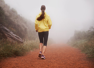 Image showing Woman, rear view and running in forest with fitness for exercise, morning routine and workout with fog and legs. Athlete, person and cardio with sportswear on outdoor trail and woods for wellness