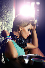 Image showing Nightclub, DJ and woman with headphones for listening to music with vinyl turntable and tech. Techno, rave and musician in light at concert stage and mix sound for party event entertainment at night