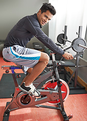 Image showing Fitness, bicycle and portrait of man in gym for cycling marathon, race or competition training. Fitness, health and athlete riding spinning machine for cardio workout or exercise in sports center.