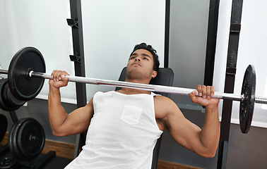 Image showing Bench, press and man at gym for exercise, workout and body building in Mexico. Healthy, person and weightlifting challenge for strong muscle, fitness or progress in training arms with barbell in club