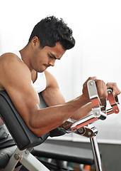 Image showing Bench, weights and man with gym machine, exercise and challenge with endurance and progress. Bodybuilder, person and guy in a health center, strong and fitness with strength training and