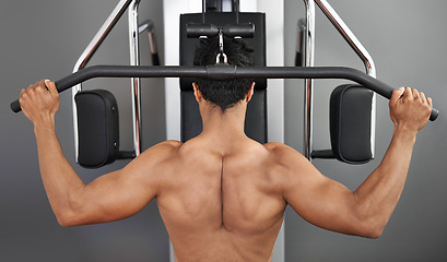 Image showing Exercise, pull down machine and man in studio on gray background for training or workout at gym. Back, health or shoulder press and body builder with equipment for wellness, strength or power