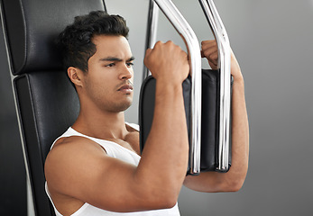 Image showing Fitness, chest exercise machine and man in studio isolated on gray background for muscle workout. Exercise, health or wellness and serious young bodybuilder athlete training with equipment at gym