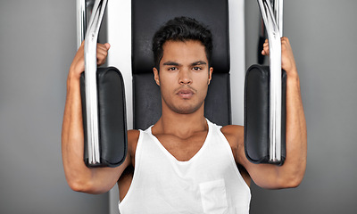 Image showing Exercise machine, portrait and man with fitness, strong and strength training with challenge and endurance. Face, bodybuilder and person in a wellness center and workout with progress and healthy